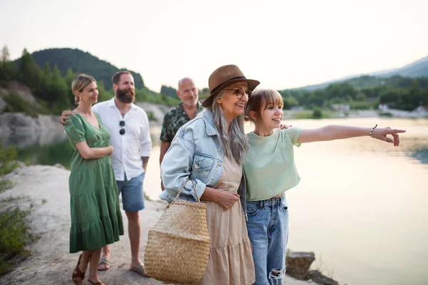 Família multigeração feliz em férias de verão, caminhando pelo lago. — Fotografia de Stock
