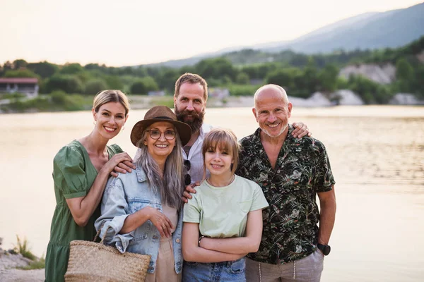 Happy multigeneration family on walk by lake on summer holiday, looking at camera. — Stock Photo, Image