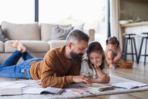 Padre con hijas adentro en casa, dibujando en el suelo. —  Fotos de Stock