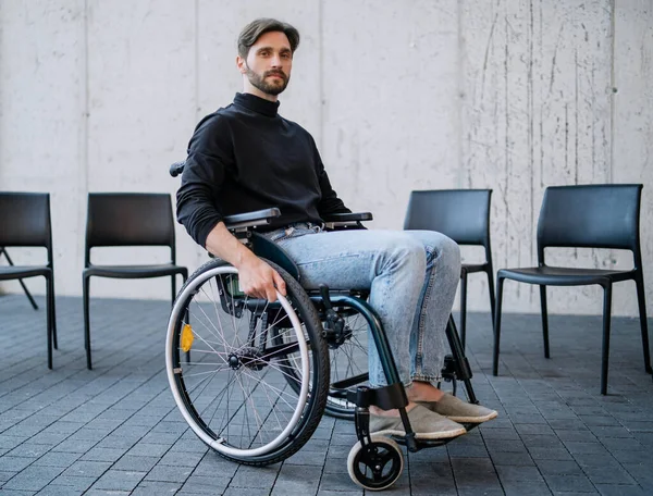 Portret van een trieste man in een rolstoel op groepstherapie, kijkend naar de camera. — Stockfoto