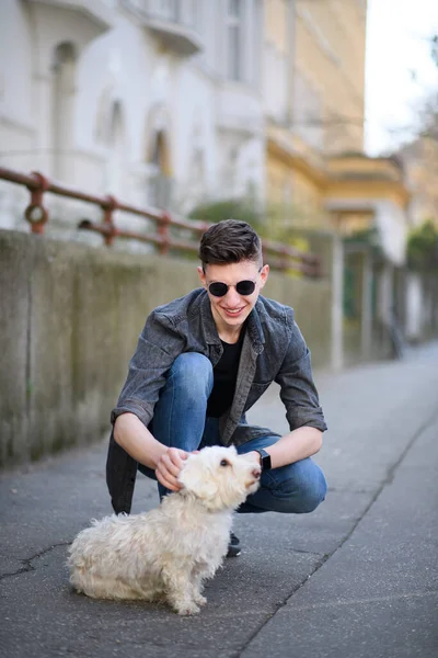 Retrato de jovem feliz com cão de estimação ao ar livre na rua na cidade. — Fotografia de Stock