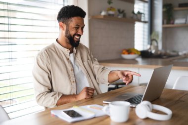 Evde, ofiste ve video çağrı konseptinde çalışan dizüstü bilgisayarı olan genç bir öğrenci..