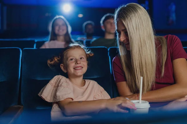 映画の中で母と幸せな小さな女の子,映画を見て. — ストック写真
