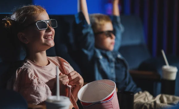 映画の中で3Dメガネとポップコーンを持つ小さな子供たち,映画を見て. — ストック写真