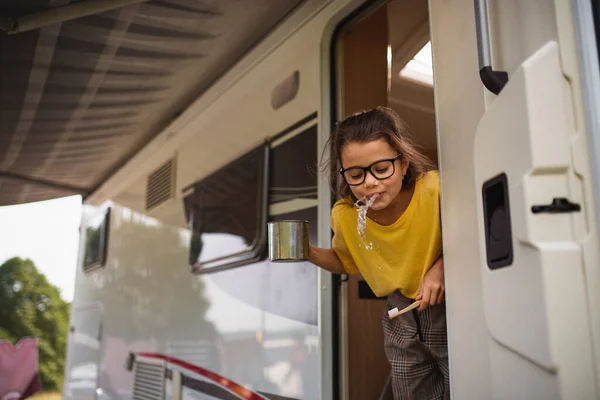 Happy kecil gadis menggosok gigi oleh karavan, liburan keluarga perjalanan. — Stok Foto