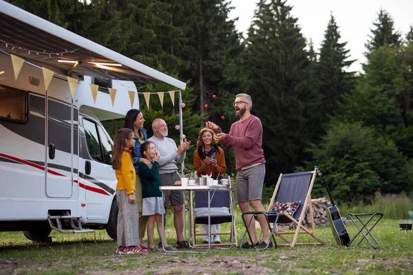 Multi-generation family standing and having fun outdoors by car, caravan holiday trip. — Stock Photo, Image