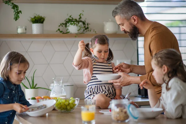 Padre con tres hijas en casa, desayunando en la cocina. — Foto de Stock