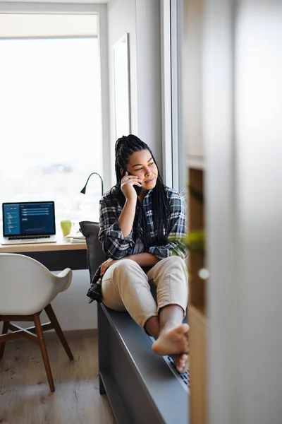 Portrait d'une adolescente heureuse étudiant assis à l'intérieur dans la chambre à coucher à la maison, en utilisant smarpthone. — Photo