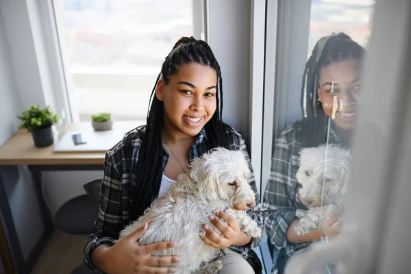 Portret szczęśliwej nastolatki z psem siedzącym w domu, patrzącym w kamerę. — Zdjęcie stockowe