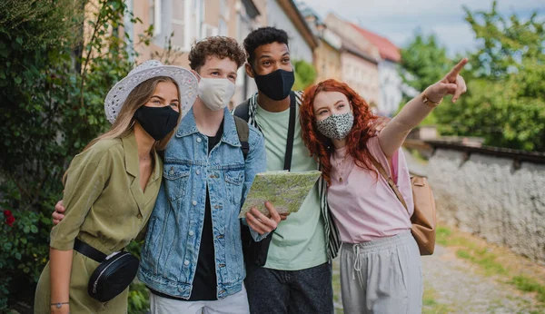 Grupo de jovens usando mapa ao ar livre em viagem na cidade, conceito coronavírus. — Fotografia de Stock