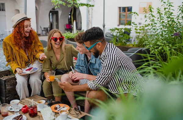 Grupa szczęśliwych młodych ludzi siedzi w kawiarni na świeżym powietrzu na wycieczkę, rozmowy. — Zdjęcie stockowe