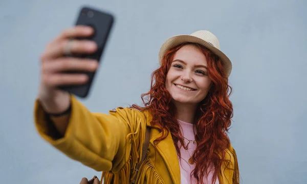 Νεαρή γυναίκα τουρίστρια σε εξωτερικούς χώρους με λευκό φόντο στο ταξίδι στην πόλη, τη λήψη selfie. — Φωτογραφία Αρχείου