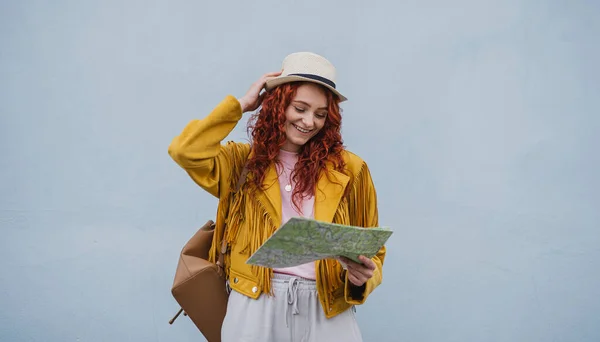 Genç bayan turist beyaz arka planda, kağıt harita kullanarak şehirde geziyor.. — Stok fotoğraf