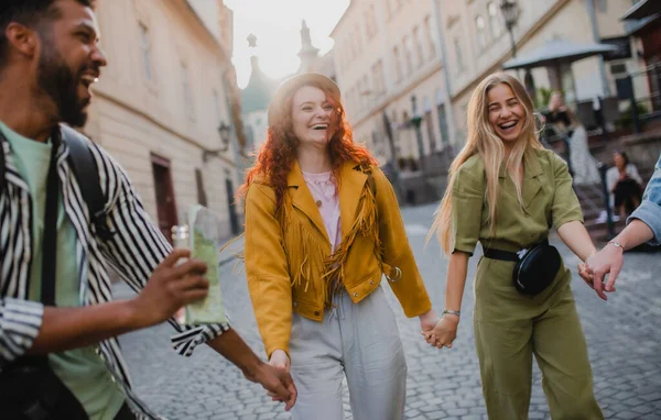 Vista frontal do grupo de jovens rindo ao ar livre na rua em viagem à cidade, caminhando. — Fotografia de Stock