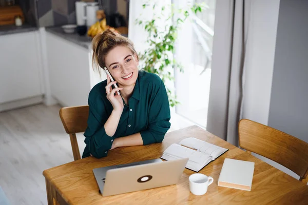 Молодая женщина студентка с ноутбуком и смартфоном на дому, домашний офис и обучение. — стоковое фото