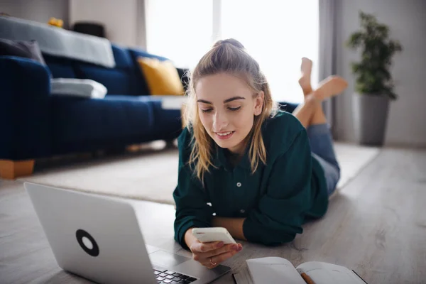 Jonge vrouw student met laptop en smartphone thuis, kantoor en leren. — Stockfoto