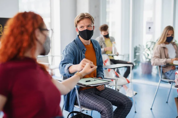 Universitaire studenten begroeten in de klas binnen, coronavirus en terug naar normaal concept. — Stockfoto