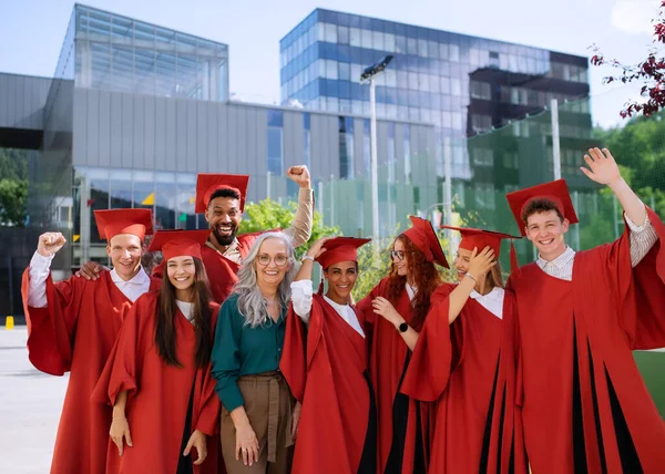 Groupe d'étudiants universitaires joyeux avec professeur célébrant à l'extérieur, regardant la caméra, concept de graduation. — Photo