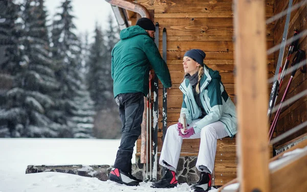 Reifes Paar rastet bei Holzhütte im Freien in winterlicher Natur, Langlauf. — Stockfoto