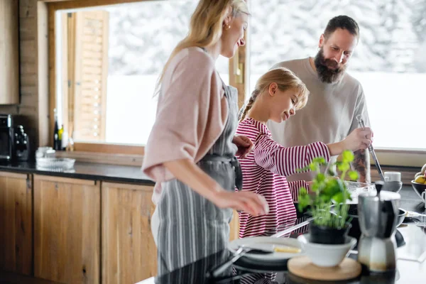 Familj med liten dotter matlagning inomhus, vinter semester i privat lägenhet. — Stockfoto