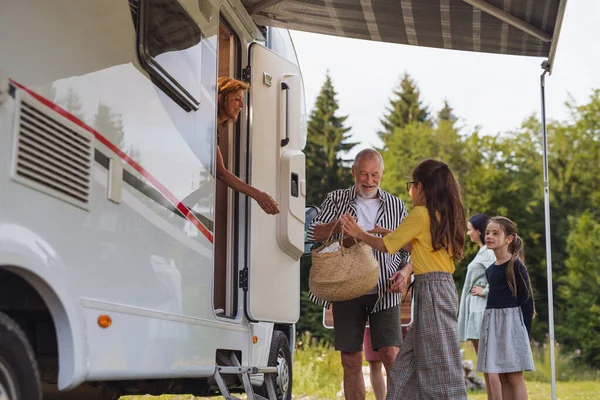 Familia multigeneración desempacando y hablando en coche, viaje de vacaciones en caravana. — Foto de Stock