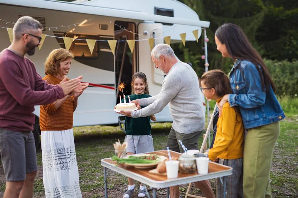 Multi-generation family celebrating birthday outdoors at campsite, caravan holiday trip. — Stock Photo, Image