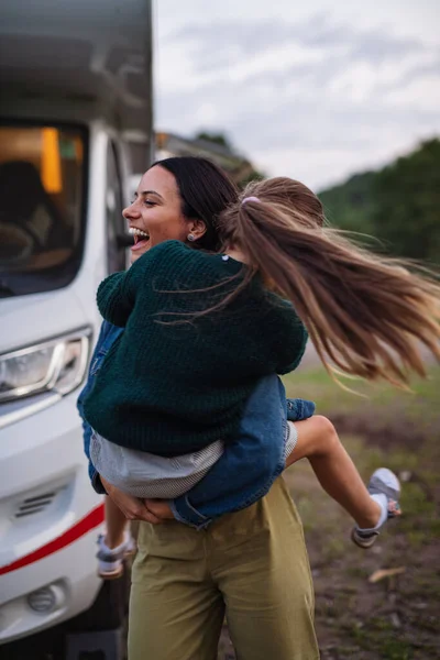 Mãe com filha se divertindo de carro ao ar livre no acampamento ao entardecer, viagem de férias em família caravana. — Fotografia de Stock