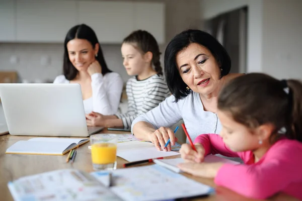 Happy kleine meisjes met moeder en grootmoeder met behulp van laptop binnen thuis, thuis kantoor en huiswerk concept. — Stockfoto