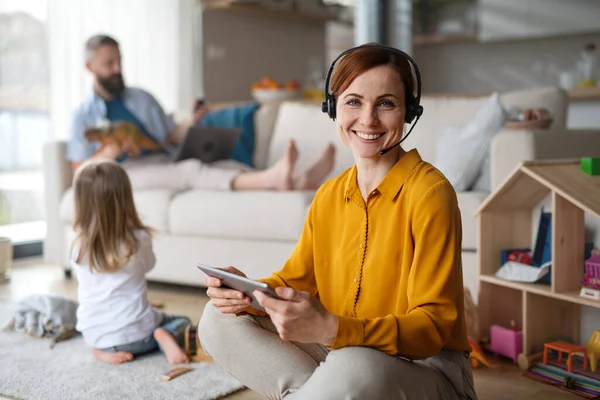 Mujer de negocios con tableta trabajando en interiores en el hogar, la vida cotidiana y la oficina en el hogar con concepto de niño. — Foto de Stock