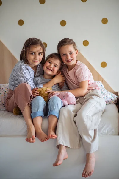 Porträt von drei Mädchen Schwestern drinnen zu Hause, Blick in die Kamera. — Stockfoto