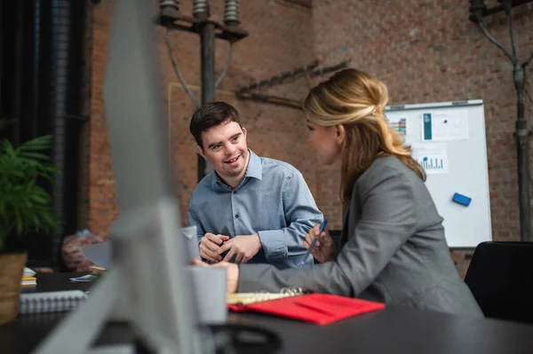 Happy Down syndroom man met zakenvrouw collega werken in het kantoor, sociale integratie en samenwerking concept. — Stockfoto