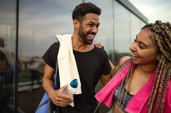 Pareja joven hablando después de hacer ejercicio al aire libre en la terraza, deporte y estilo de vida saludable concepto. — Foto de Stock