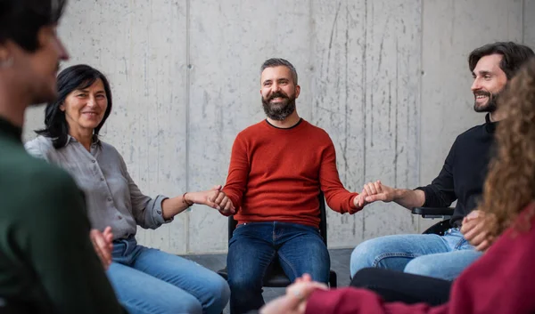 Män och kvinnor som sitter i cirkel under gruppterapi och håller hand. — Stockfoto