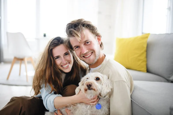 Feliz joven pareja enamorada de perro en casa, mirando a la cámara. —  Fotos de Stock