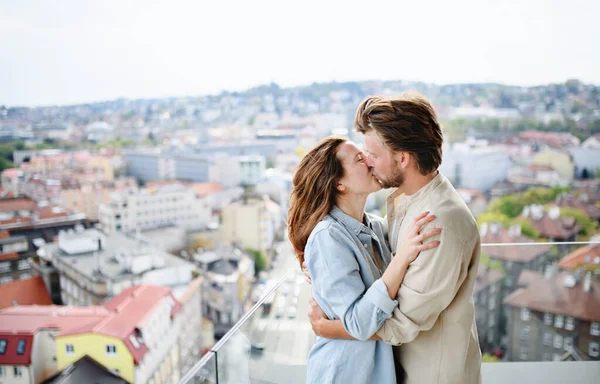 Feliz jovem casal apaixonado de pé ao ar livre na varanda em casa, beijando. — Fotografia de Stock