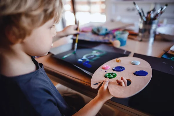 Soustředěný malý chlapec malování obrázků doma, volný čas. — Stock fotografie