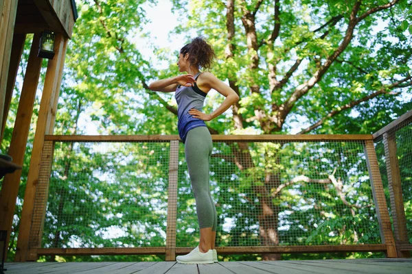 Feliz mujer adulta haciendo ejercicio al aire libre en la terraza de la casa del árbol, fin de semana de distancia y concepto de desintoxicación digital. — Foto de Stock