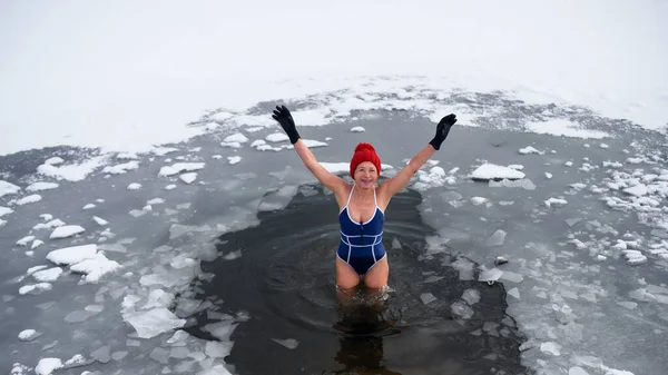 Wysoki kąt widzenia aktywnej starszej kobiety w stroju kąpielowym na zewnątrz w zimie, koncepcja zimnej terapii. — Zdjęcie stockowe