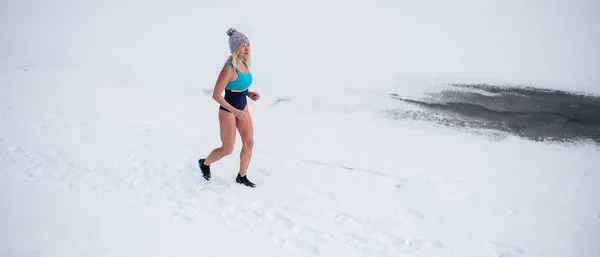 Mayo giymiş, kışın dışarıda koşan aktif yaşlı bir kadın. Soğuk terapi konsepti.. — Stok fotoğraf