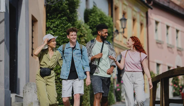 Vista frontal do grupo de jovens felizes ao ar livre em viagem na cidade, caminhando e conversando. — Fotografia de Stock