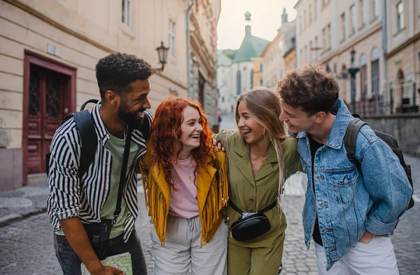 Vista frontal do grupo de jovens felizes ao ar livre na rua em viagem à cidade, se divertindo. — Fotografia de Stock