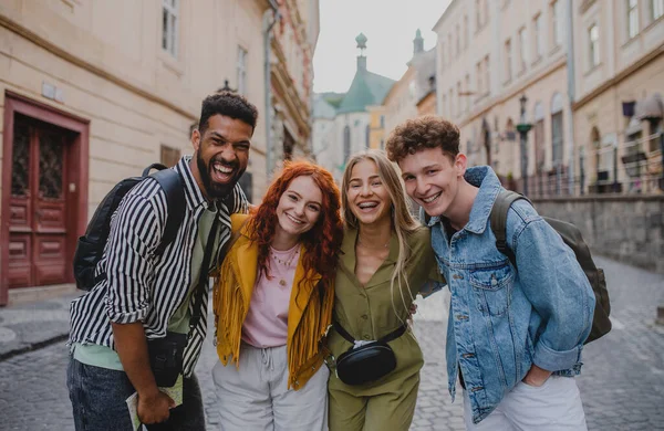 Vista frontal do grupo de jovens felizes ao ar livre em viagem na cidade, olhando para a câmera. — Fotografia de Stock