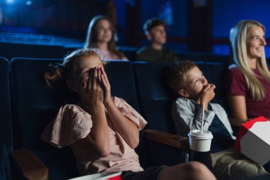 Anne ve küçük çocuklar sinemada film izliyor..