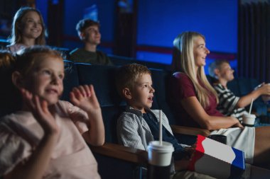 Anne ve küçük çocukları sinemada film izliyorlar..