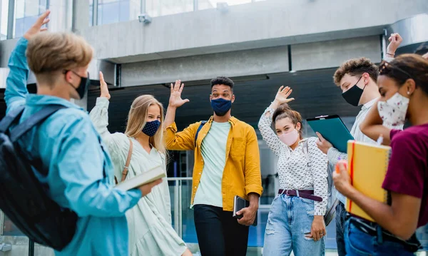 Студенты университета стоят и приветствуют на открытом воздухе, коронавирус и вернуться к нормальной концепции. — стоковое фото