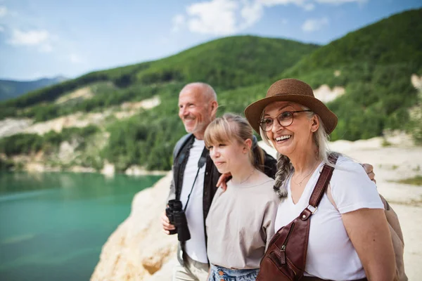 Chica preadolescente feliz con abuelos en viaje de senderismo en vacaciones de verano, caminando. — Foto de Stock