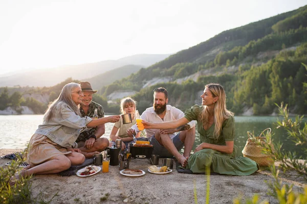 Happy multigeneration family on summer holiday trip, barbecue by lake. — Stock Photo, Image