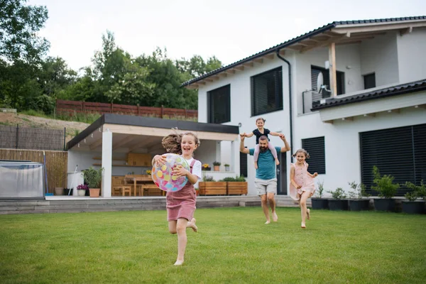 Father with three daughters playing outdoors in the backyard, running. — Stock Photo, Image