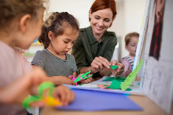 Group of small nursery school children with teacher indoors in classroom, art and craft concept. — Stock Photo, Image