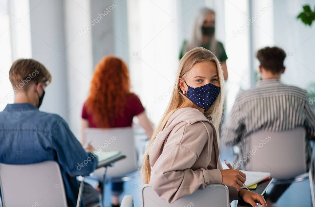 Portrait of university student in classroom indoors, coronavirus and back to normal concept.
